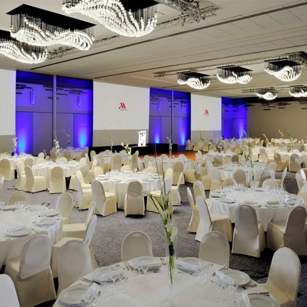 Modern artistic wavy hanging crystal chandelier, with a black metal frame and dense crystal particles creating a flowing wavy shape, combining decorative and main lighting functions, suitable for large-scale commercial spaces such as large banquet halls, exhibition centers, and high-end clubs.