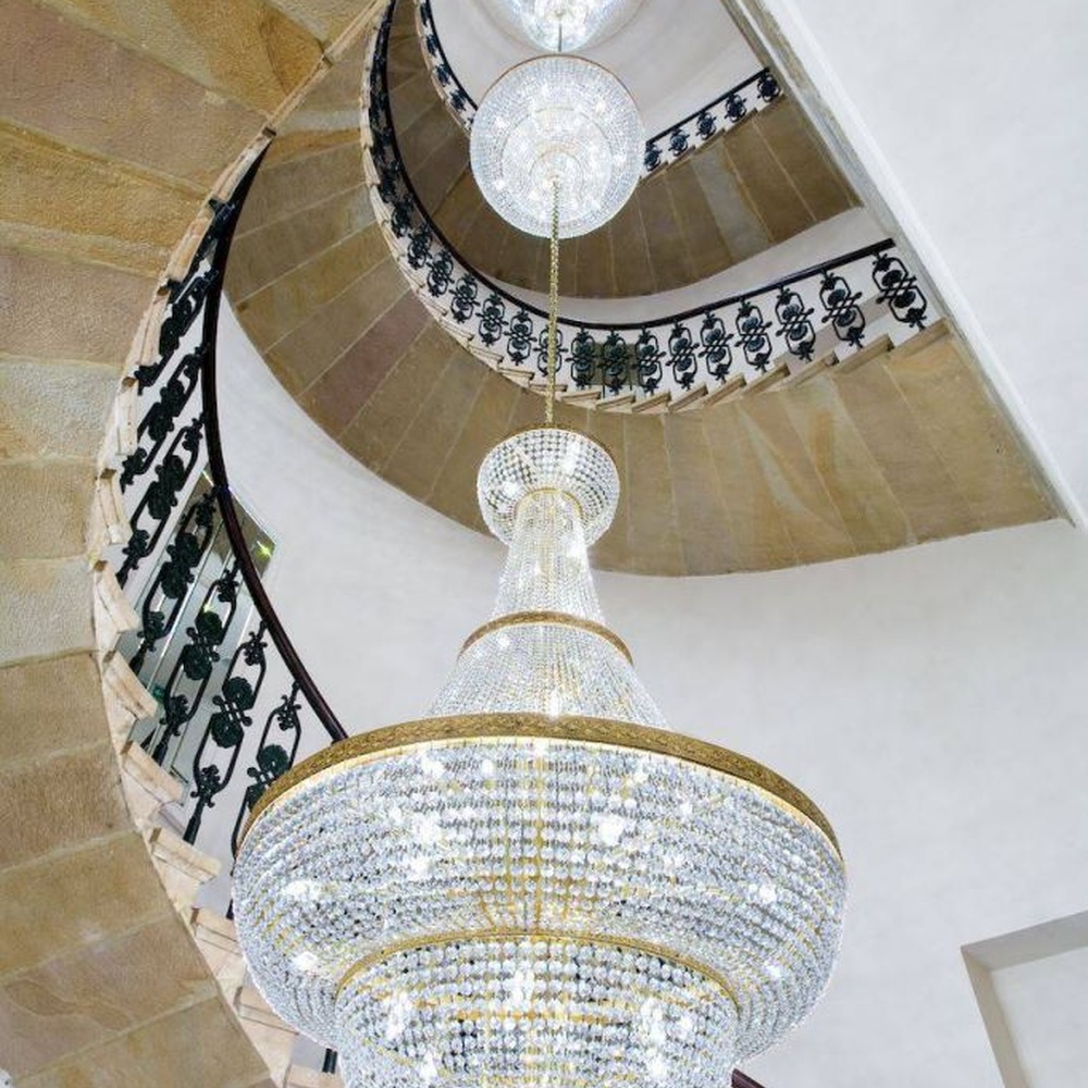This European court-style golden goblet vase multi-layer crystal chandelier features a gold metal frame paired with dense high-transparency crystals, forming a multi-layer tower structure in the shape of a vase, with brilliant and luxurious light, serving both lighting and decorative purposes, suitable for high-end high-ceiling spaces such as villa high-ceiling staircases and hotel lobbies.