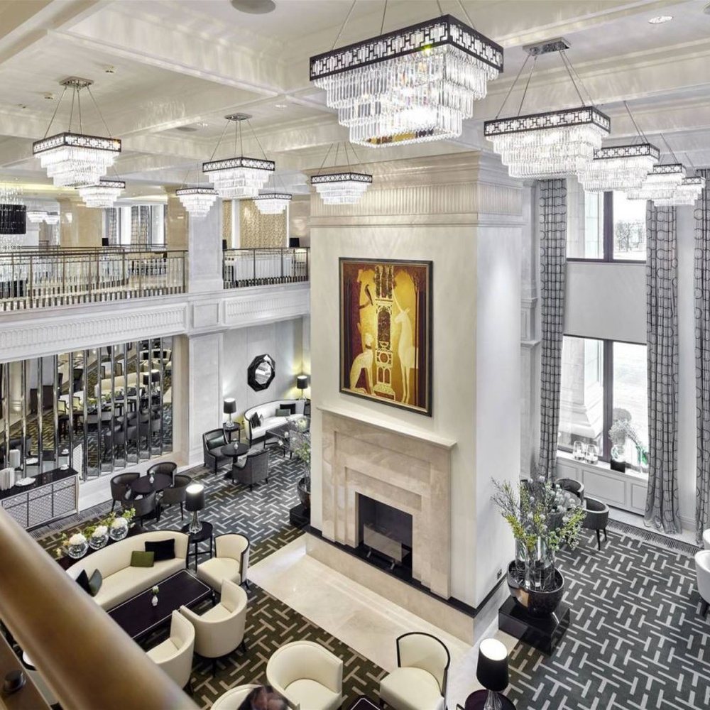 Modern light luxury rectangular multi-layer crystal chandelier, with a black-framed metal frame and layered transparent crystal strips, featuring bright and soft light, combining decorative and lighting functions, suitable for hotel lobbies, high-end clubs, commercial atriums and other high-ceiling commercial spaces.