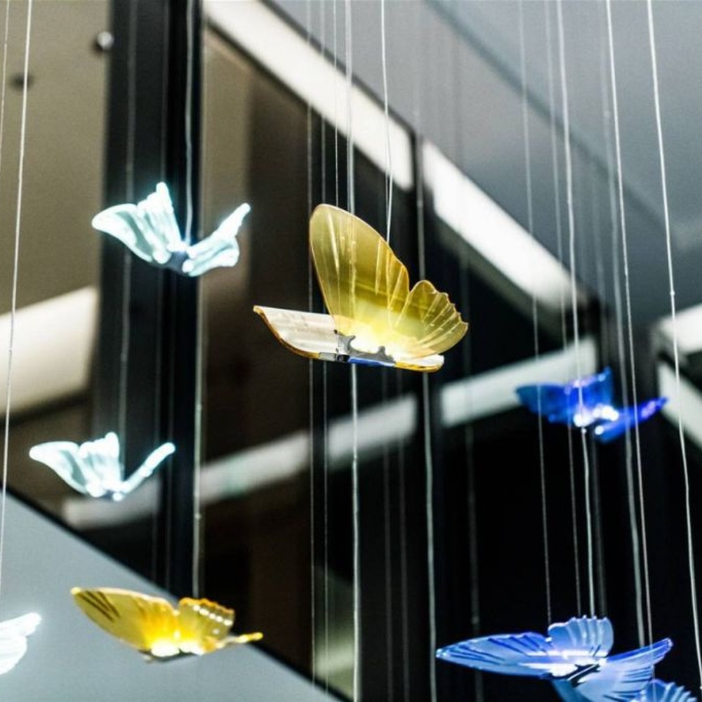 Modern artistic butterfly-shaped suspended chandelier, made of colored glass/acrylic to create a realistic butterfly form, paired with adjustable metal suspension rods, combining decorative and ambient lighting functions, suitable for hotel lobbies, high-end clubs, art exhibition halls and other spaces.