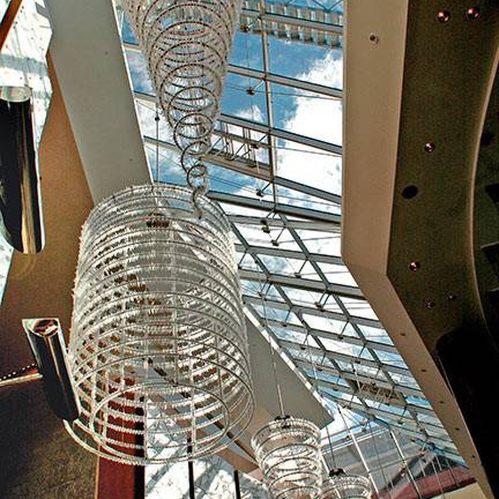 Modern luxury spiral crystal chandelier, made of stacked crystal strips and metal structure to create a suspended tornado shape with strong visual impact. It combines artistic decoration and main lighting functions, suitable for hotel lobbies, high-end clubs, high-ceiling office spaces and other venues.