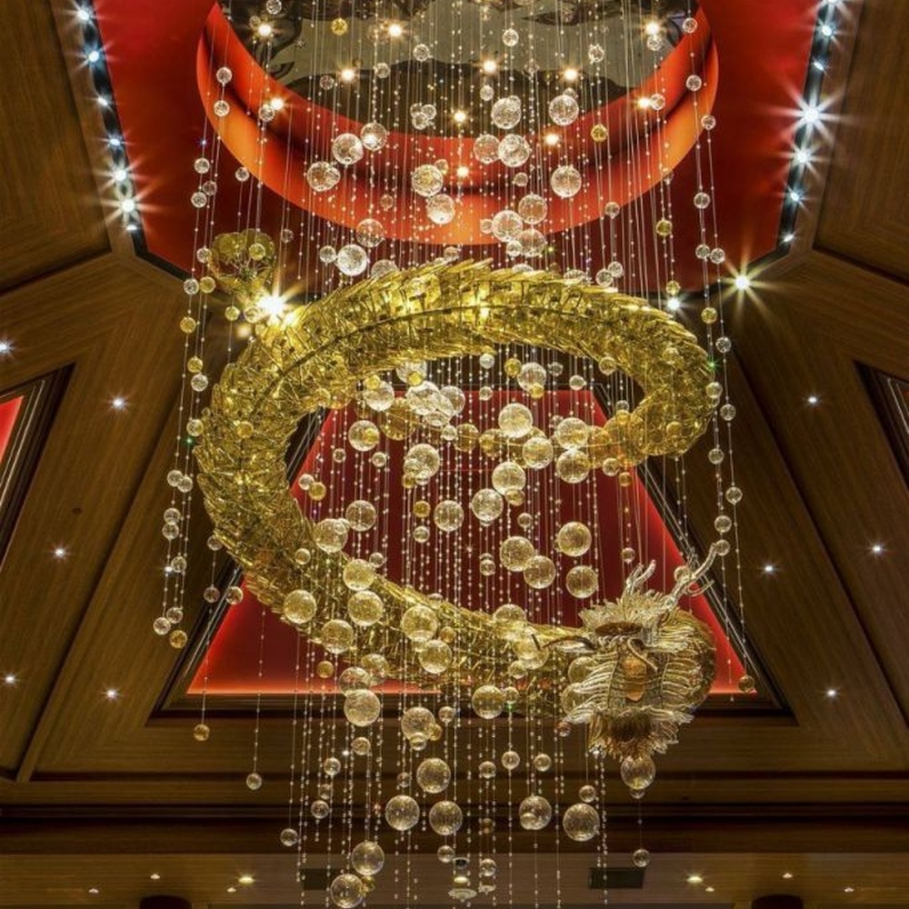 This large multi-layer ring crystal chandelier features a red-gold contrasting metal frame paired with dense crystal beads and gold ring decorations, with dazzling light, serving both lighting and decorative purposes, suitable for luxury commercial spaces such as casinos and high-end clubs.