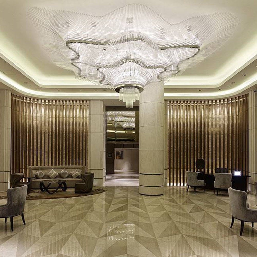 This large wave-shaped crystal ceiling lamp consists of dense high-transparency crystal strips forming a flowing wave pattern, covering the entire ceiling, with soft and brilliant light, serving both lighting and installation art purposes, suitable for large high-ceiling spaces such as hotel lobbies and high-end commercial atriums.