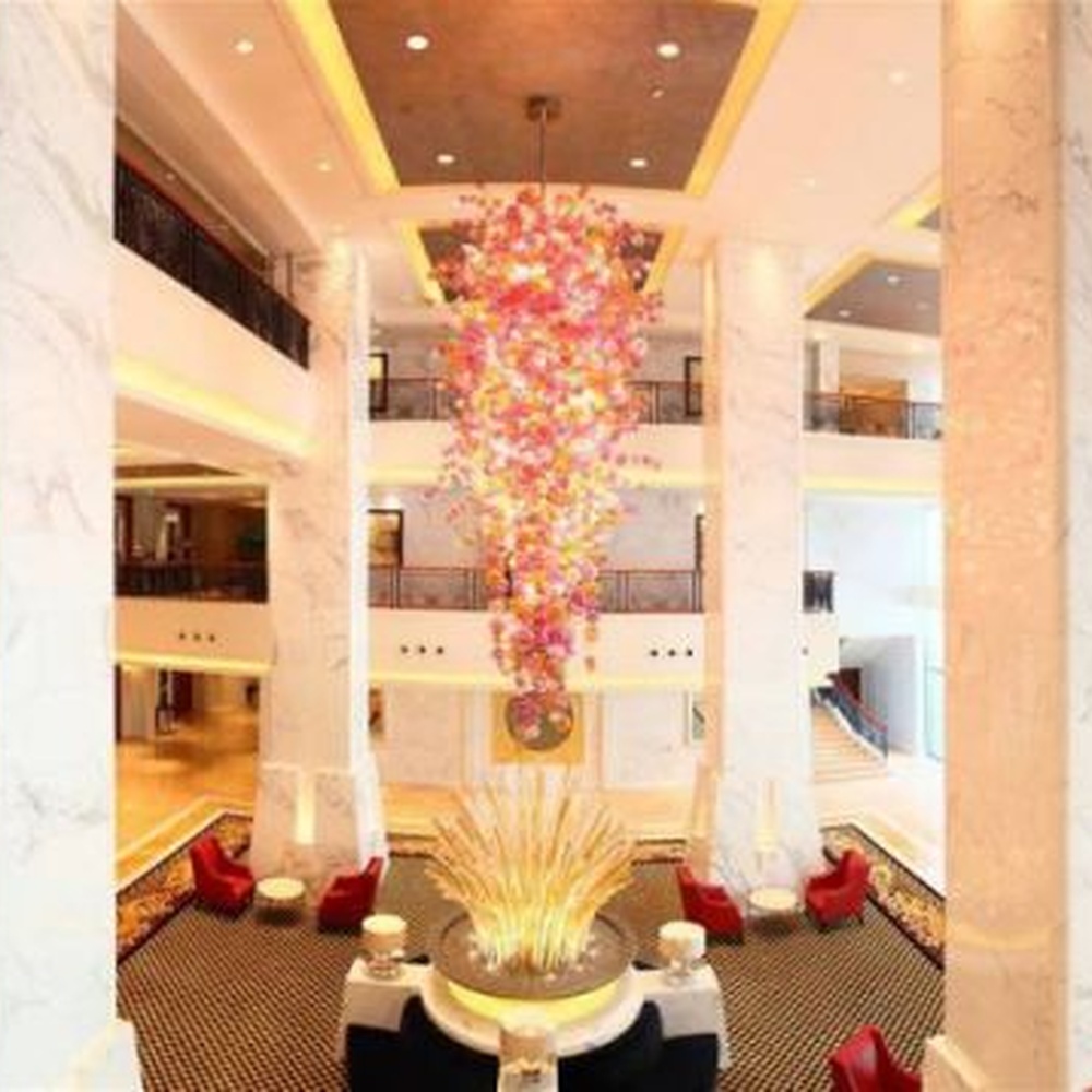 Modern artistic flower cluster-shaped hanging chandelier, with pink-orange gradient crystal/acrylic petals stacked into a full flower cluster shape, combining artistic decoration and main lighting functions, suitable for high-ceiling large-scale spaces such as hotel lobbies, high-end clubs, and commercial atriums.
