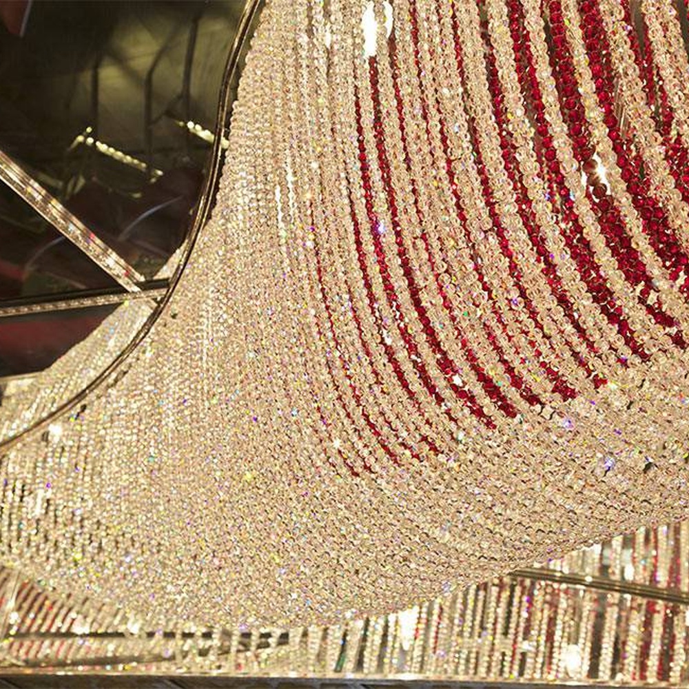 Modern luxury red-white gradient wavy crystal ceiling lamp, with dense crystal particles creating a flowing wavy shape, the red-white gradient texture has strong visual tension, combining decorative and main lighting functions, suitable for large-scale commercial spaces such as high-end banquet halls, clubs, and hotel lobbies.