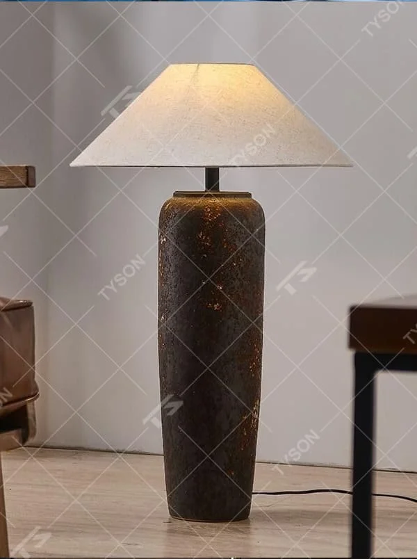 This is a retro industrial-style floor lamp with a dark brown aged texture lamp post and a white fabric slanted lampshade. It features a retro and rustic design with industrial texture. It is used for space lighting and decoration, creating a retro industrial atmosphere. It is suitable for retro industrial-style home living rooms, loft-style apartments, art studios and other places.