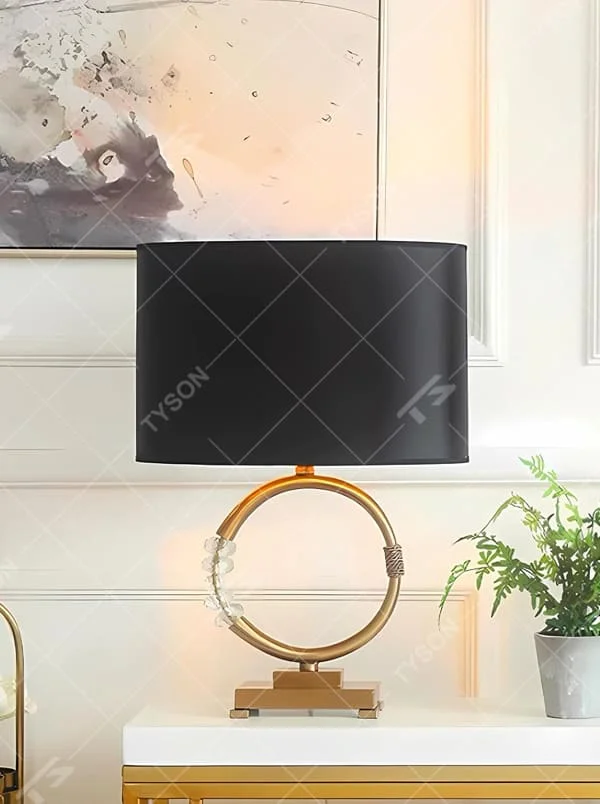This is a luxurious retro-style table lamp with a golden circular base, a black fabric lampshade, and crystal elements, featuring an elegant and grand design. It is used for local desktop lighting and decoration, enhancing the luxurious retro ambiance of the space. It is suitable for luxury-style home living room side tables, high-end hotel guest rooms, retro-style clubs and other places.