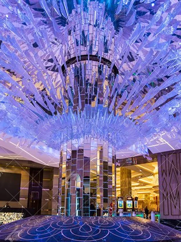 This is a large artistic crystal chandelier, composed of numerous irregular transparent sheet-like components. It has a layered, art-sculpture-like design and presents a luxurious and dreamy effect with purple lighting. It is used for decorating the space and providing lighting, with both artistic sense and practicality. It is suitable for high-end hotel lobbies, luxury casinos, large banquet halls and other high-end places.