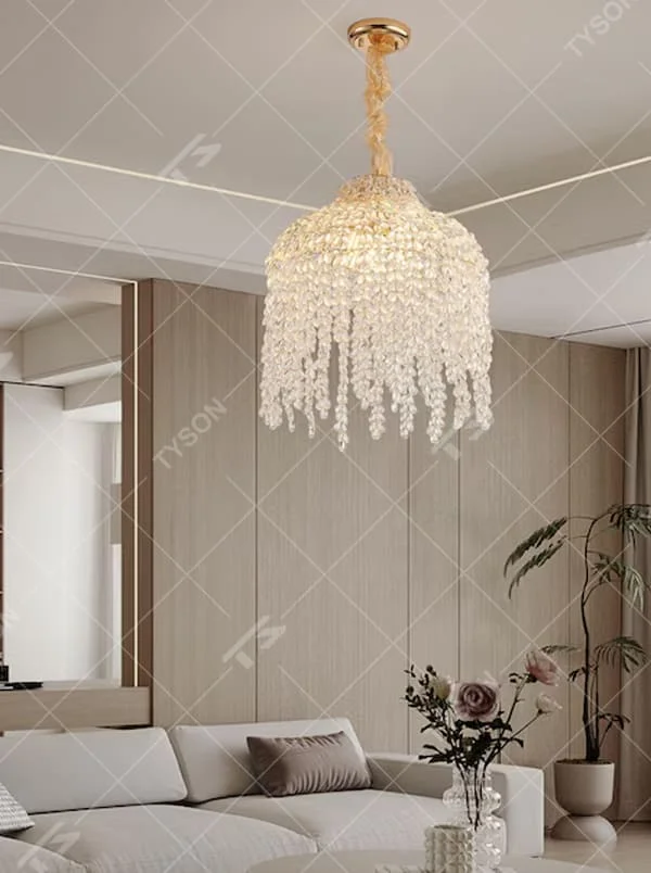 This is a luxury crystal chandelier with a golden base and cascading crystal string design, featuring a luxurious and elegant style that shows brilliant texture under light. It is used for space lighting and decoration, creating a noble and luxurious ambiance. It is suitable for luxury-style home living rooms, high-end hotel guest rooms, luxury restaurants and other places.