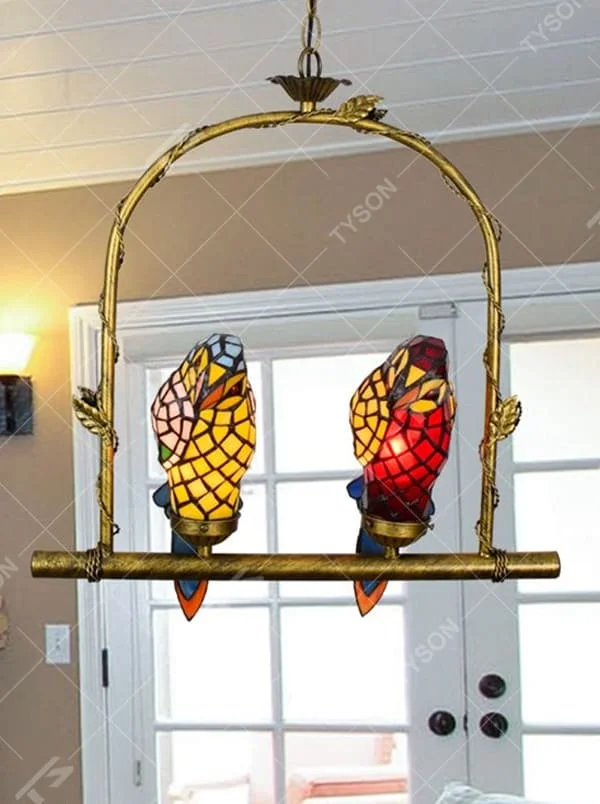 This is an artistic chandelier with a golden metal frame and two parrot - shaped colored glass lamp bodies, which are vivid and unique, full of childlike fun and artistic sense. It is used for both lighting and decoration, adding personality and vitality to the space through the unique parrot shape. It is suitable for themed restaurants, characteristic homestays, art cafes, children's rooms and other places.