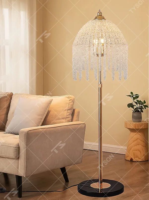 This is a luxury crystal floor lamp with a golden lamp pole, a marble base, and a cascading crystal lampshade. It features a luxurious and elegant design that shines brilliantly under light. It is used for space lighting and decoration, creating a noble and luxurious ambiance. It is suitable for luxury-style home living rooms, high-end hotel leisure areas, luxury villa living rooms and other places.