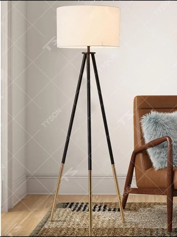 This is a modern tripod - shaped floor lamp with a black - gold metal tripod stand and a dark brown fabric cylindrical lampshade, featuring a minimalist luxury design with strong modern sense. It is used for space lighting and decoration, creating a warm and luxurious atmosphere. It is suitable for modern home living rooms, luxury - style residences, leisure reading areas and other places.
