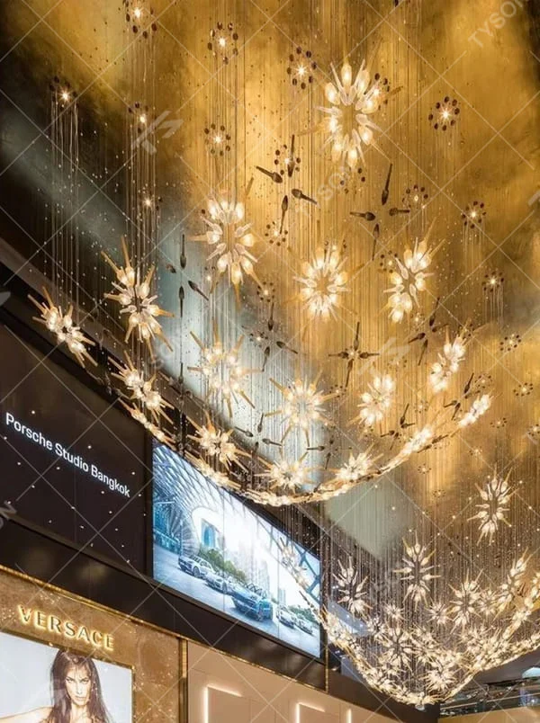 This is an artistic radial flower-shaped glass chandelier, with multi-layer colored glass components (gold, transparent, etc.) in a radial flower design, hanging structure, featuring strong artistic sense and visual hierarchy. It is used for space lighting and artistic decoration, creating a luxurious artistic atmosphere. It is suitable for high-end hotel lobbies, art exhibition halls, luxury clubs and other places.