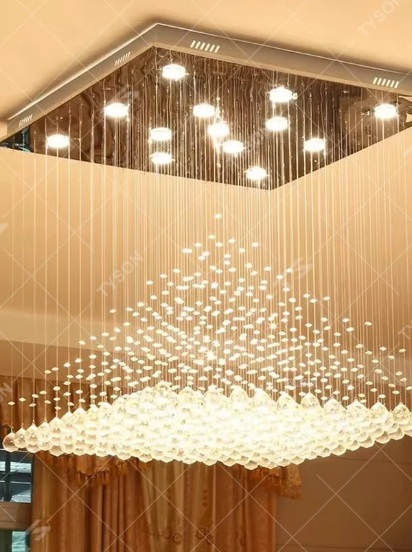 This is a luxury square crystal ceiling light, with a square metal frame and multi-layer transparent crystal pendants, brilliant lighting, featuring a magnificent and grand design with strong visual impact. It is used for space lighting and decoration, creating a high-end luxury atmosphere. It is suitable for high-ceilinged living rooms, luxury villas, high-end hotel lobbies and other places.