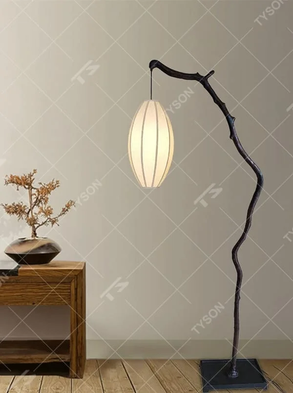 This is a new Chinese Zen-style floor lamp with a dark branch-shaped lamp pole and a beige fabric lantern lampshade. It features a natural and rustic design with a strong Zen sense. It is used for space lighting and decoration, creating a natural Zen ambiance. It is suitable for new Chinese-style home living rooms, Zen teahouses, art homestays and other places.