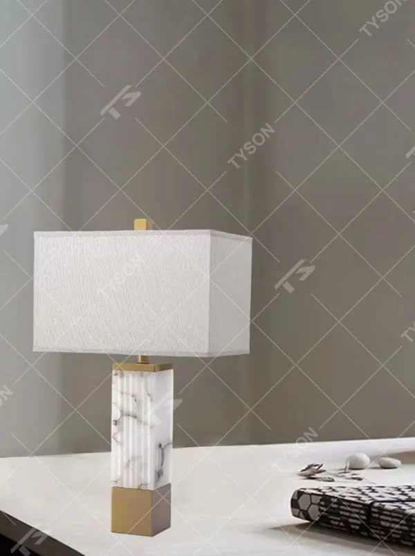 This is a luxury marble table lamp, with a white marble (textured) base, golden metal components, and a white fabric square lampshade, featuring a minimalist luxury design with high-quality texture. It is used for local desktop lighting and decoration, creating a high-end luxury atmosphere. It is suitable for luxury-style home bedroom bedside tables, high-end hotel guest rooms, modern soft decoration display spaces and other places.