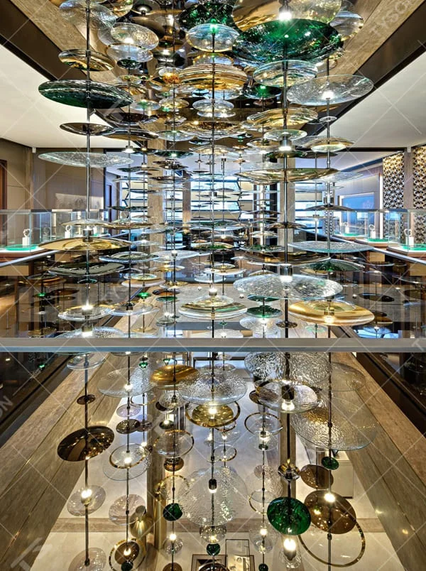 This is an artistic multi-layer glass disc chandelier, composed of multi-colored glass discs (gold, green, transparent, etc.) hung in multiple layers, featuring a strong artistic sense and visual hierarchy. It is used for space lighting and artistic decoration, creating a luxurious artistic atmosphere. It is suitable for high-end commercial exhibition halls, art spaces, luxury hotel lobbies and other places.