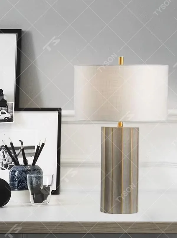 This is a luxury artistic agate-textured table lamp, with a golden metal frame inlaid with blue agate texture decoration and a white square fabric lampshade, featuring a minimalist and grand design with both artistic sense and luxury texture. It is used for local desktop lighting and decoration, creating a luxury artistic atmosphere. It is suitable for luxury-style home bedroom bedside tables, high-end hotel guest rooms, art exhibition hall display tables and other places.