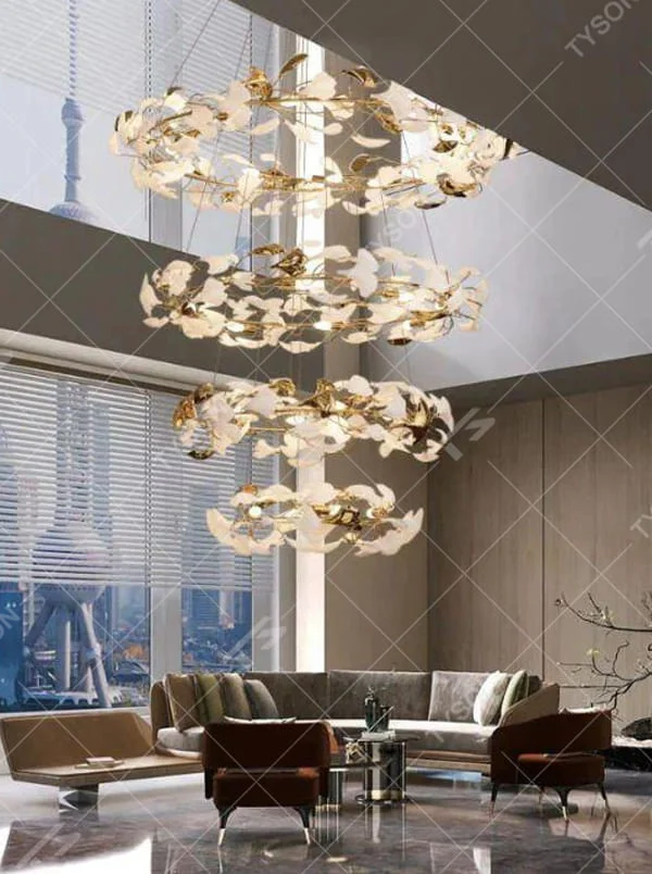 This is a new Chinese luxury ginkgo leaf multi-layer chandelier, with a golden metal frame and white ginkgo leaf design, featuring natural art and luxury texture. It is used for space lighting and decoration, creating a natural luxury ambiance. It is suitable for high-end residential double-height living rooms, luxury hotel lobbies, art clubs and other places.