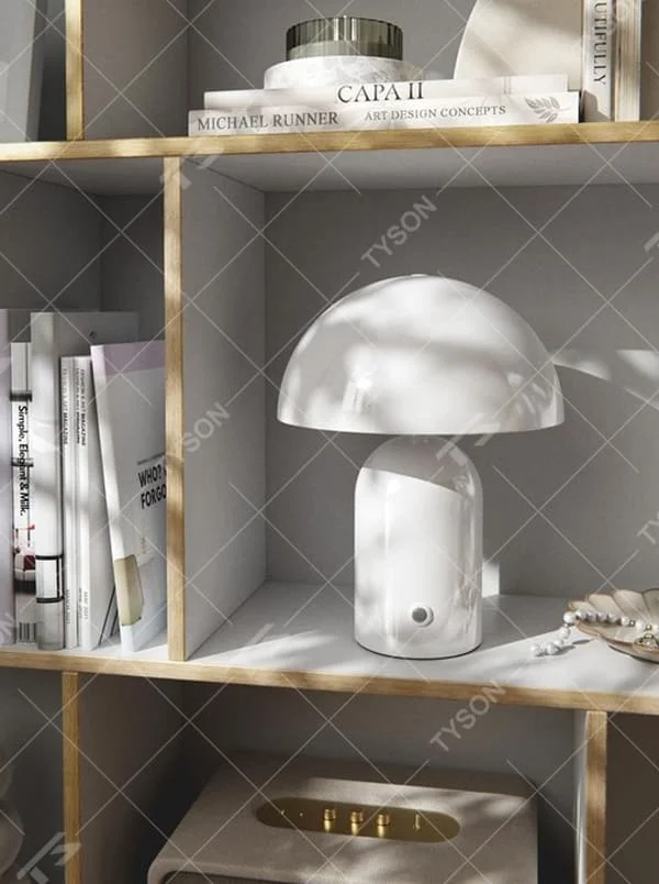 This is a minimalist mushroom-shaped table lamp with a white rounded mushroom lampshade and a simple base, featuring a fresh and cute design with a warm ambiance. It is used for local desktop lighting and decoration, creating a minimalist and warm atmosphere. It is suitable for Nordic-style home bedrooms, children's rooms, minimalist office spaces and other places.