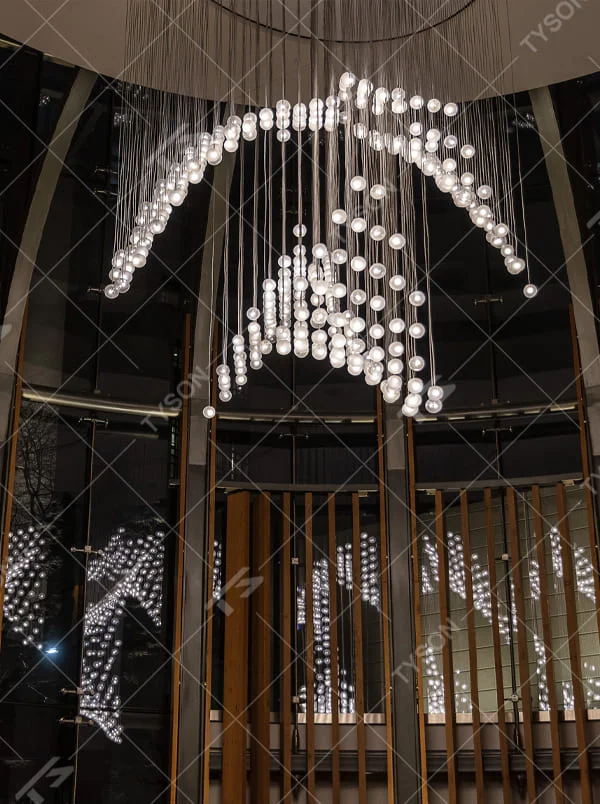 This is a modern artistic spherical light cluster chandelier with numerous white spherical lights arranged in a creative cluster via hanging wires. It features a highly immersive and artistic design with a futuristic ambiance. It is used for space lighting and decoration, creating a stunning visual focus and immersive light-shadow atmosphere. It is suitable for atriums of large commercial complexes, lobbies of high-end hotels, art galleries and exhibition halls and other places.