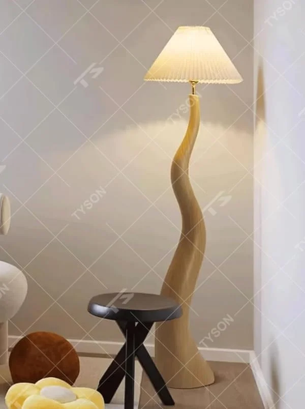This is a natural artistic wooden curved floor lamp, with a light wood irregular curved bracket and a pleated fabric lampshade, featuring a strong sense of art and natural atmosphere. It is used for space lighting and decoration, creating a natural artistic ambiance. It is suitable for Nordic-style home living rooms, art homestays, creative studios and other places.