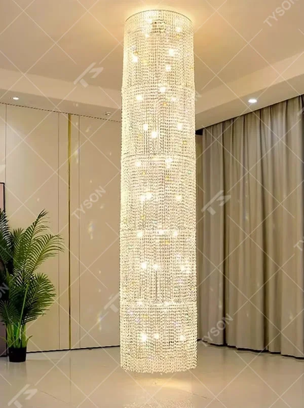 This is a luxury cylindrical crystal chandelier, made of full crystal material, with multi-layer crystals forming a cylindrical shape, brilliant lighting, featuring a magnificent and luxurious design with strong visual impact. It is used for space lighting and decoration, creating a high-end luxury atmosphere. It is suitable for high-end hotel lobbies, luxury banquet halls, large commercial exhibition halls and other places.