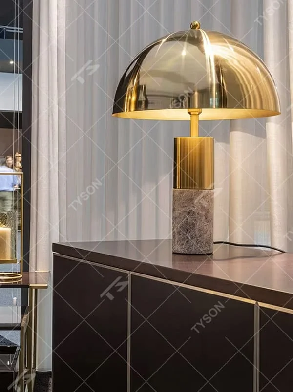 This is a luxury-style gold-brown marble table lamp, with a golden dome lampshade, golden metal pole, and brown marble base, featuring a minimalist and grand design with strong luxury texture. It is used for local desktop lighting and decoration, creating a luxury and modern atmosphere. Suitable for luxury-style home bedroom bedside tables, high-end hotel guest rooms, modern minimalist living room side tables and other places.