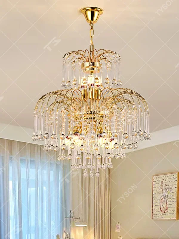 This is a luxurious classical golden multi-layer crystal chandelier, with a golden metal frame paired with numerous transparent crystal pendants. It features a magnificent and grand design, with brilliant lighting. It is used for space lighting and decoration, creating a luxurious and noble atmosphere. Suitable for luxury living rooms, high-end hotel lobbies, villa banquet halls and other places.