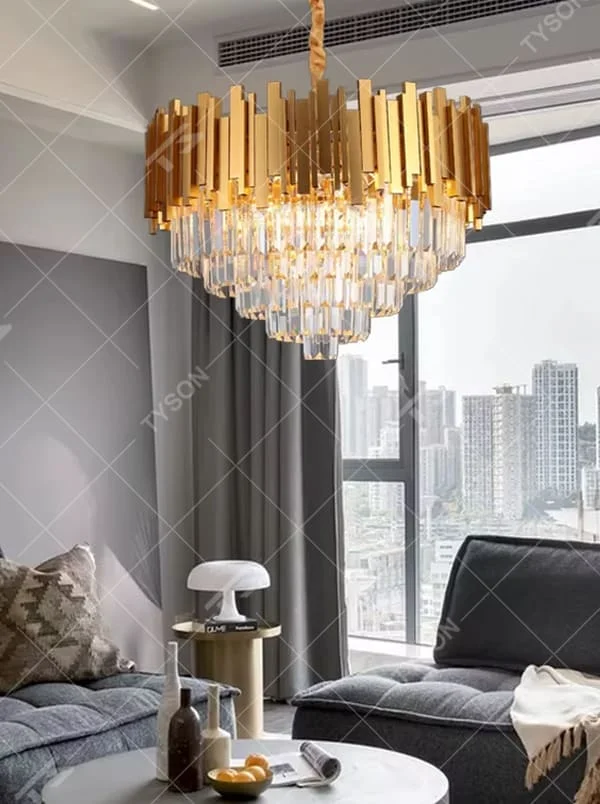 This is a luxurious modern-style golden column crystal chandelier, with a golden metal column structure and transparent crystals, featuring a grand and luxurious design, brilliant lighting. It is used for space lighting and decoration, creating a high-end luxurious atmosphere. Suitable for luxury villa living rooms, high-end hotel lobbies, light luxury-style restaurants and other places.