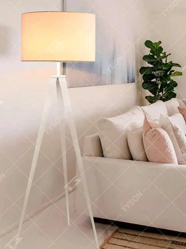 This is a modern minimalist white tripod fabric floor lamp, with a white metal tripod structure and a beige fabric round lampshade. It features a minimalist and grand design, with soft lighting. It is used for space ambient lighting and decoration, creating a modern minimalist atmosphere. Suitable for modern minimalist living rooms, Nordic-style homes, light luxury apartments and other places.