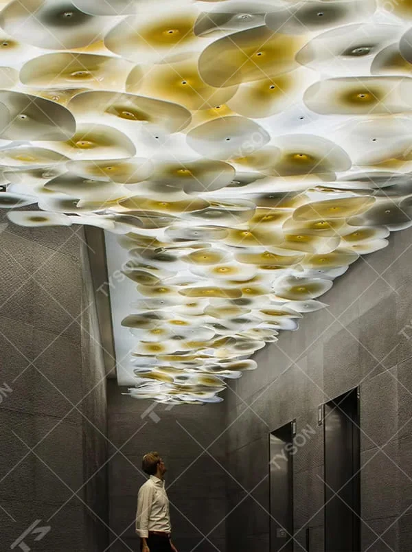 This is a modern artistic multi-layer disc glass art chandelier, composed of numerous gradient gold and white disc glass elements hanging in layers to form a three-dimensional ceiling decorative shape. It features soft and artistically layered lighting, with a strong sense of modern art and spatial decorativeness. It is used for space lighting and artistic installation decoration, creating a modern artistic and high-end elegant atmosphere. Suitable for high-end hotel lobby corridors, art exhibition halls, luxury commercial spaces and other places.