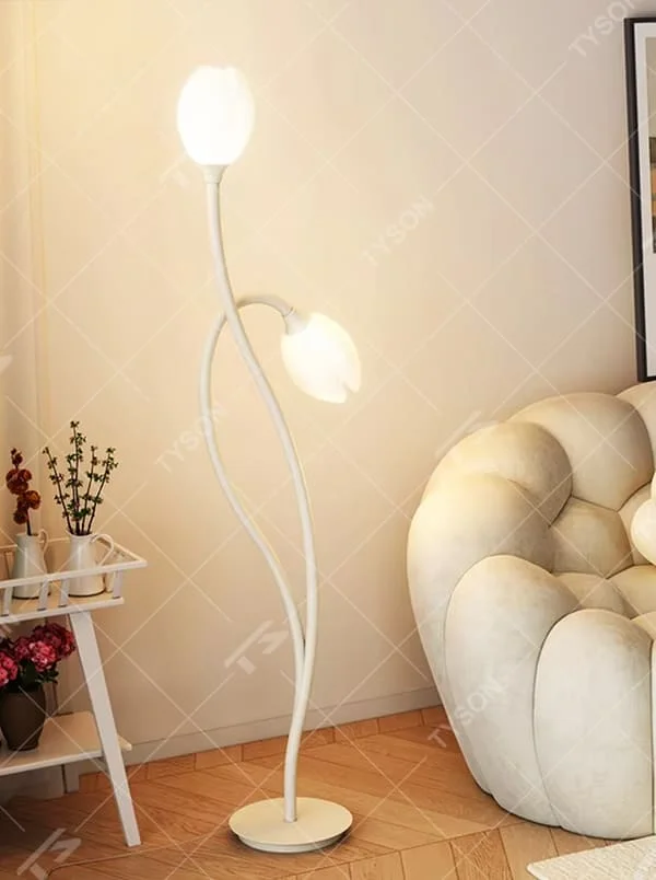 This is a modern warm-style white flower-shaped floor lamp, with white curved metal poles and double flower-shaped lampshades, featuring a minimalist and gentle design, warm style. It is used for space lighting and decoration, creating a warm and comfortable atmosphere. Suitable for modern minimalist living rooms, bedroom corners, Nordic-style homes and other places.