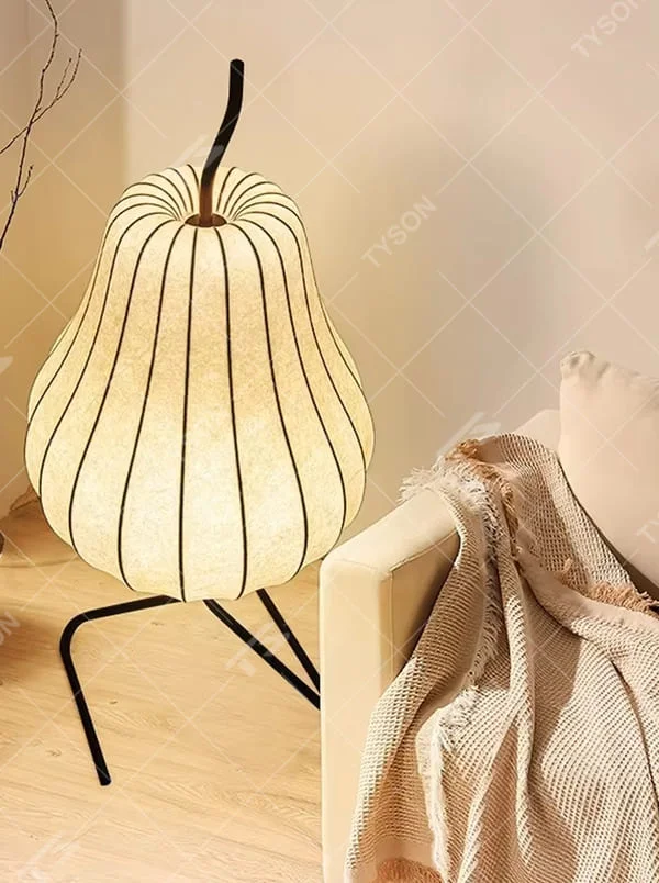 This is a childlike artistic pear-shaped floor lamp, made of paper-like material to create a pear shape, paired with a black metal stand. It features a childlike and natural design, with warm and soft lighting. It is used for space ambient lighting and decoration, creating a childlike and natural atmosphere. Suitable for Nordic-style homes, literary homestays, children's rooms and other places.
