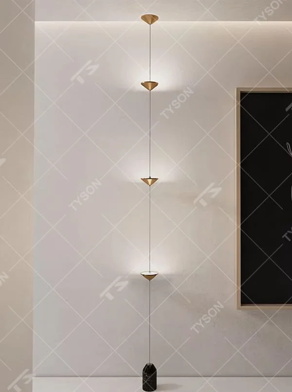 This is a modern artistic golden conical long-string chandelier, with multiple golden conical lamp bodies connected in series and a black marble base, featuring a minimalist artistic design and modern style. It is used for space lighting and decoration, creating an artistic and modern atmosphere. Suitable for modern art home stairwells, high-ceilinged living rooms, designer studios and other places.