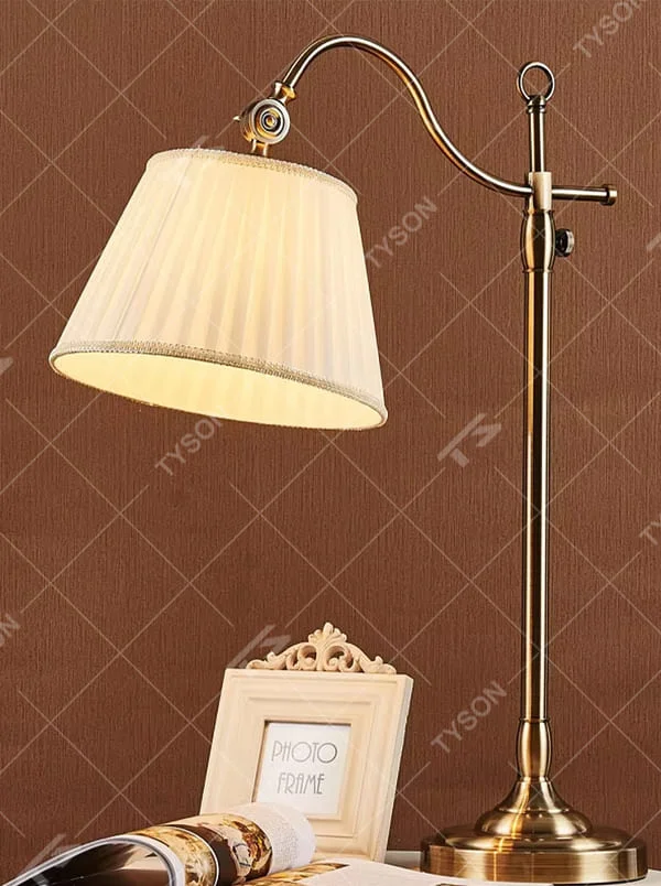 This is a retro European-style brass fabric table lamp, with a brass metal structure (with an adjustable curved arm and decorative details) and a beige pleated fabric lampshade. It features an exquisite retro design and soft warm lighting. It is used for local desktop lighting and decoration, creating a retro and warm atmosphere. Suitable for European-style bedrooms, studies, retro-style living rooms and other places.