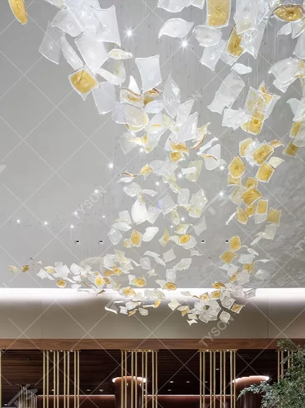This is an artistic installation-style glass piece chandelier, with numerous transparent and golden glass pieces hanging in a scattered manner, featuring strong artistic sense, and the light reflects a brilliant visual effect. It is used for space lighting and artistic decoration, creating a luxurious artistic atmosphere. Suitable for high-end hotel lobbies, art exhibition halls, luxury shopping mall atriums and other places.