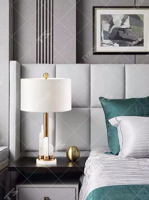 Light luxury white shade gold decorative marble base table lamp, white fabric lampshade + golden metal decorations + white marble base, soft lighting, creating a high-end elegant atmosphere.