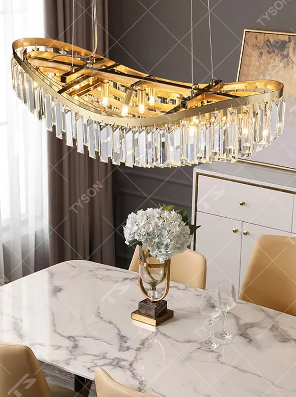 Light luxury golden curved long crystal chandelier, decorated with transparent crystal strips, brilliant and high-end lighting, creating a high-end light luxury atmosphere.
