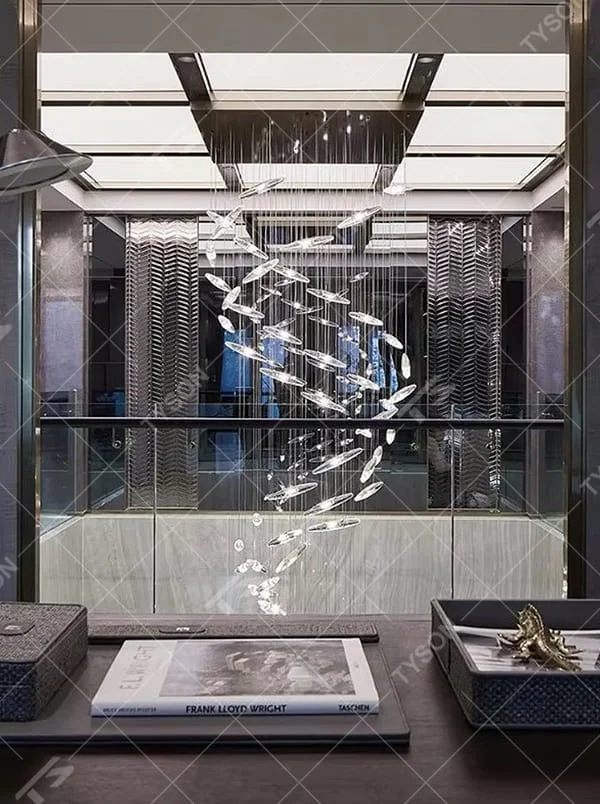 This is a modern artistic fish school-shaped hanging chandelier, featuring multiple silver fish-shaped decorations (crystal/metal texture) suspended by thin wires. The design is dynamic, modern and full of artistic tension, with brilliant and exquisite lighting. It is used for space lighting and artistic decoration, creating a high-end modern artistic atmosphere. Suitable for high-ceiling areas of high-end hotels, luxury commercial clubs, modern art villas and other places.