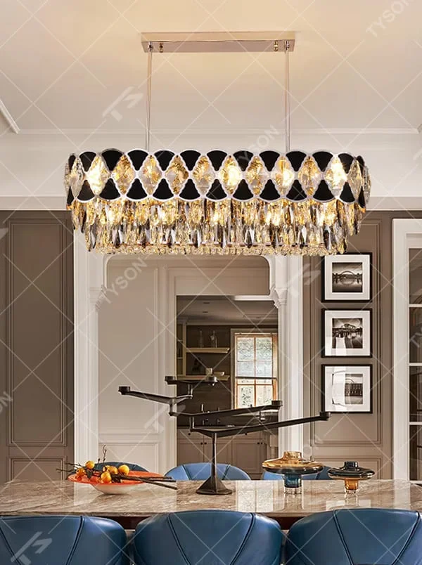 This is a light luxury and luxurious long strip chandelier, with black-silver diamond decorations on the upper layer and golden crystal pendants hanging on the lower layer. When lit, the light is brilliant and high-end, creating a high-end luxurious atmosphere.