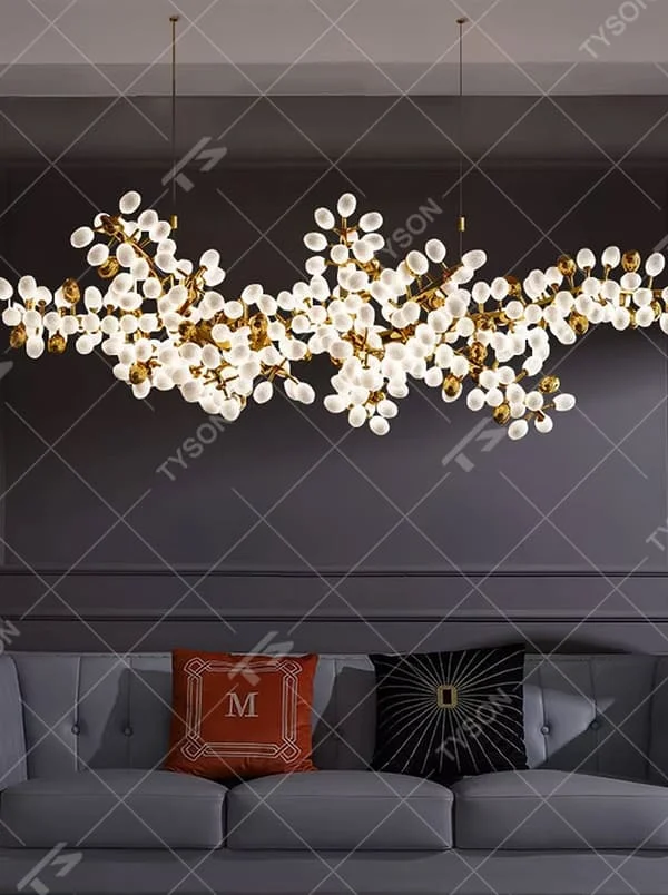 This is a light luxury artistic long strip flower branch-shaped chandelier, with golden metal branches paired with a large number of white spherical lampshades. The shape is like blooming flower branches, with soft and brilliant lighting, creating a light luxury artistic atmosphere.