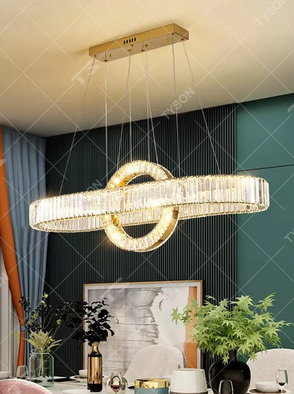 This is a light luxury and luxurious long strip ring crystal chandelier, with a golden metal frame paired with transparent crystals, adopting a combination of long strip and ring shape. When lit, the light is brilliant and gorgeous, creating a high-end light luxury atmosphere.