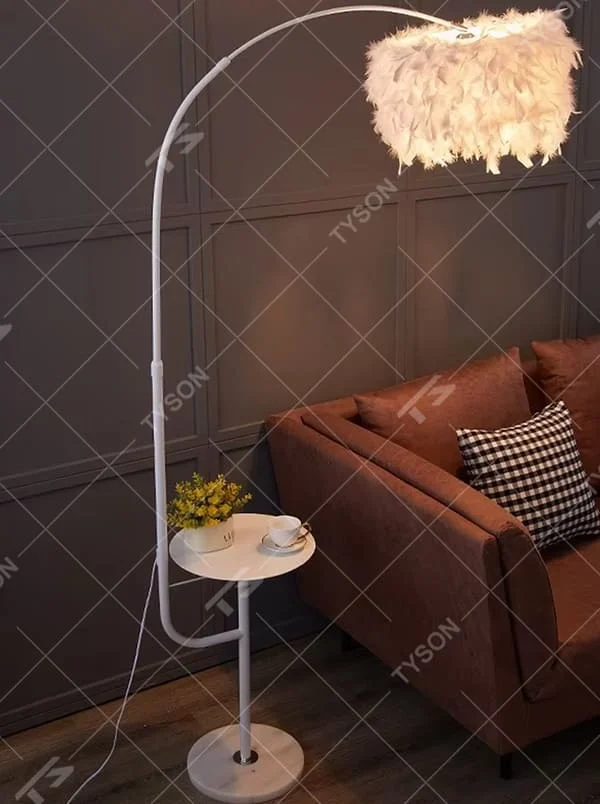 Warm romantic-style white curved feather floor lamp with a small round storage table, white feather lampshade + white lamp pole + round base, soft and warm lighting, creating a comfortable romantic space atmosphere.