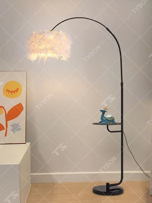 This is a warm romantic-style curved feather floor lamp, with a black curved lamp pole paired with a white feather lampshade, and a small tray (for storage). The lighting is soft and warm, creating a comfortable romantic atmosphere.