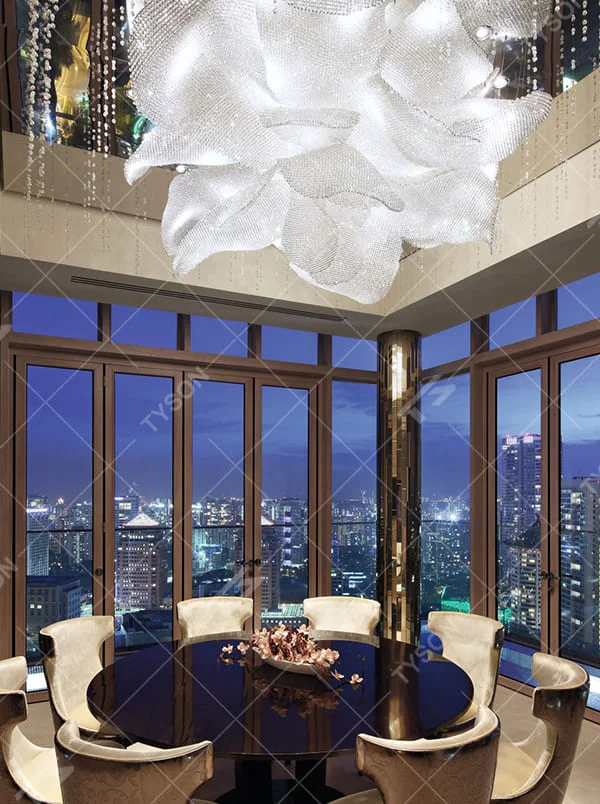 This is a luxurious artistic crystal petal-shaped chandelier, crafted with white crystals in a blooming flower shape. When lit, the light is brilliant and gorgeous, creating a high-end luxurious space atmosphere.