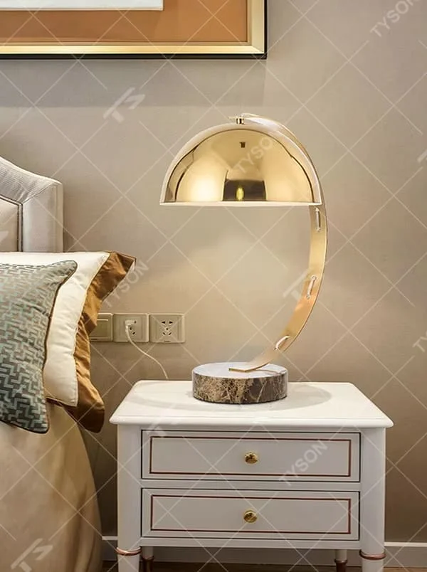 Light luxury golden curved hemisphere table lamp, marble-patterned round base, soft and warm lighting, creating a high-end elegant space atmosphere.