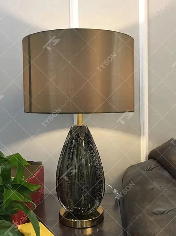 Light luxury dark brown fabric lampshade teardrop-textured table lamp, black-gray textured base + golden base, soft lighting, creating a high-end elegant atmosphere.
