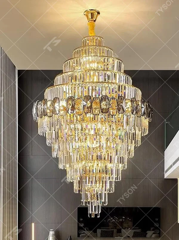 This is a luxurious multi-layer crystal tower chandelier, with a golden metal frame paired with transparent + gradient crystals (decorated with dark crystals), a layered tower shape. When lit, the light is brilliant and gorgeous, creating a high-end luxurious atmosphere.