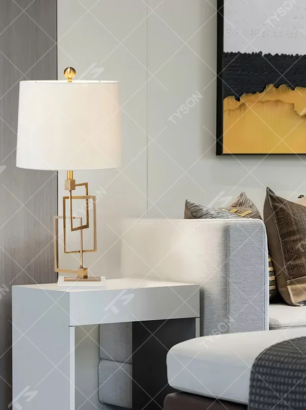 Light luxury modern geometric square frame gold stand table lamp, golden multi-layer square frame stand + beige fabric cylindrical lampshade + white stone base, soft and high-end lighting, creating a light luxury minimalist atmosphere.